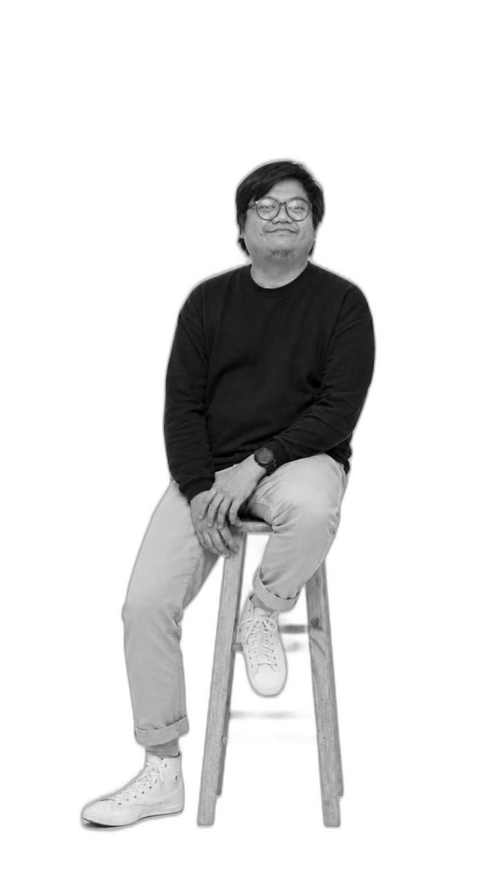 Black-and-white portrait of Dana F. Zumario seated on a wooden stool
